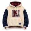 Cream sherpa varsity hoodie with navy sleeves and chenille letter patch