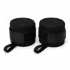 Pair of rolled black boxing hand wraps with hook and loop closure and thumb loop